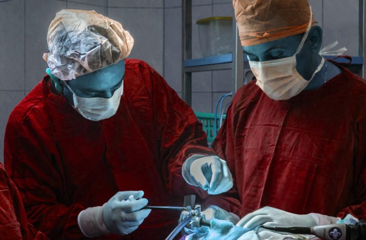 the healthcare debate, NHS, two surgeons are operating on a patient